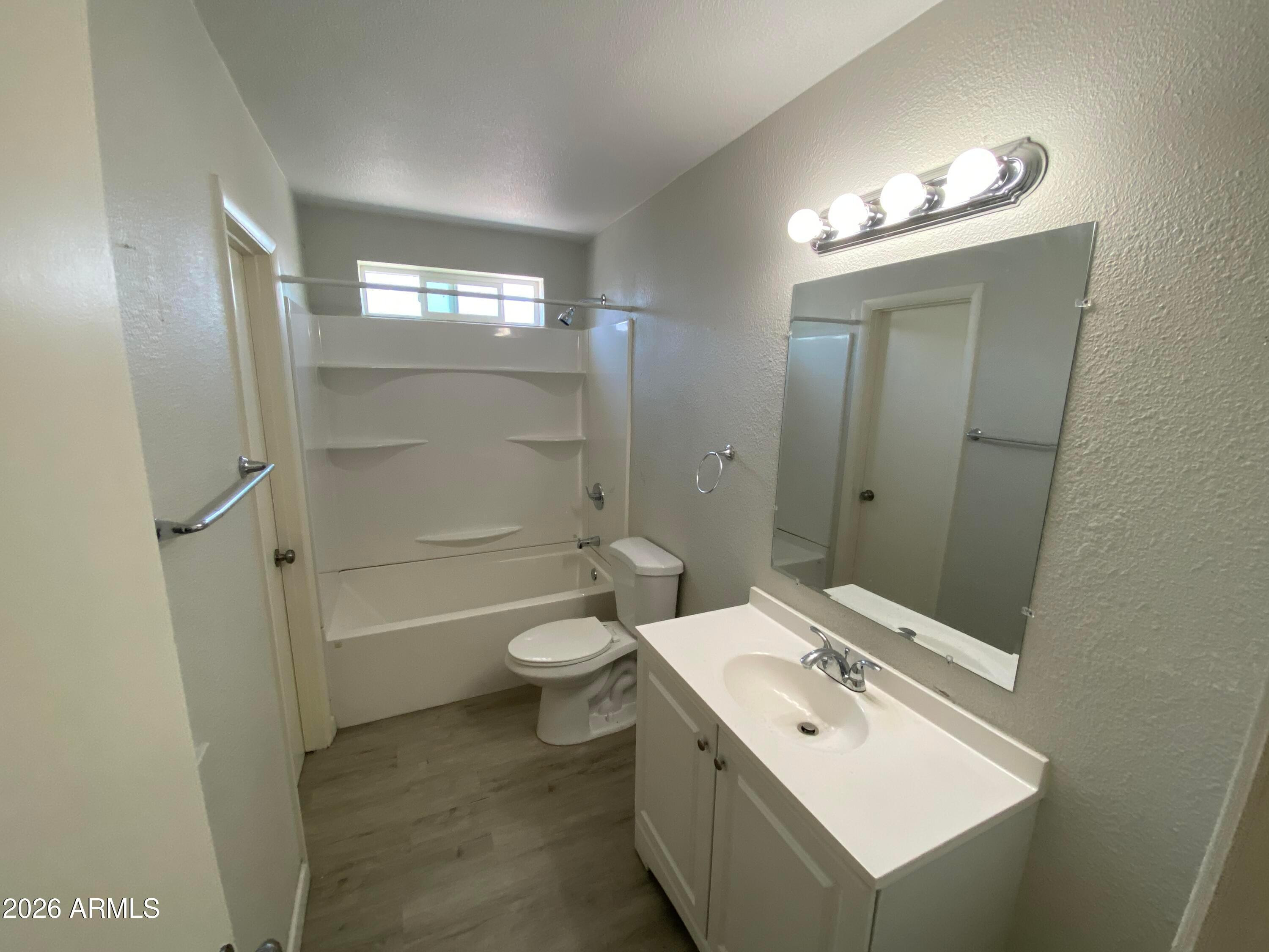 1124 North 27th Street, Unit 4 Phoenix, AZ 85008 - Photo 7 of 9 a bathroom with a toilet sink and mirror