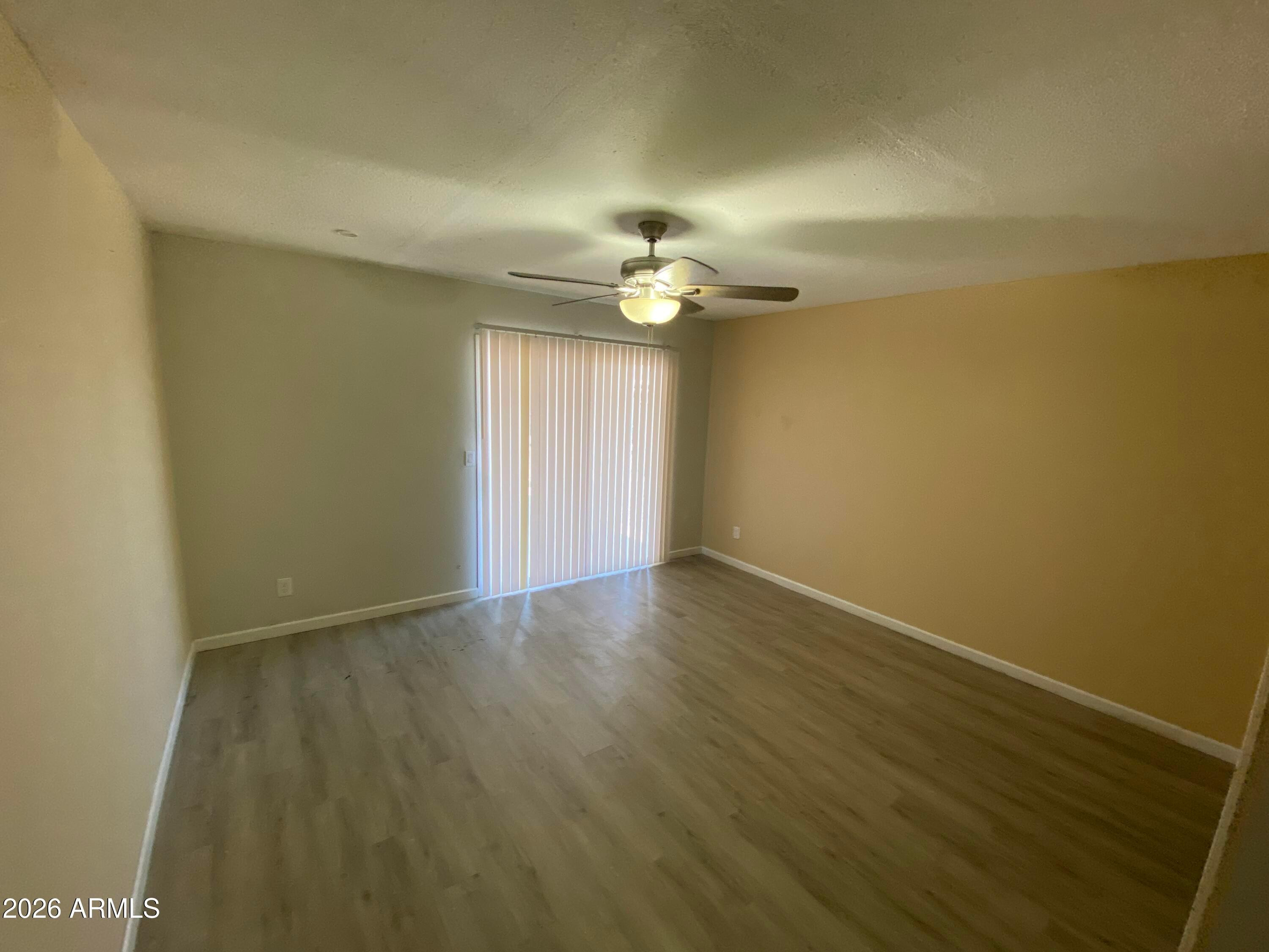 1124 North 27th Street, Unit 4 Phoenix, AZ 85008 - Photo 8 of 9 an empty room with a window and a ceiling fan