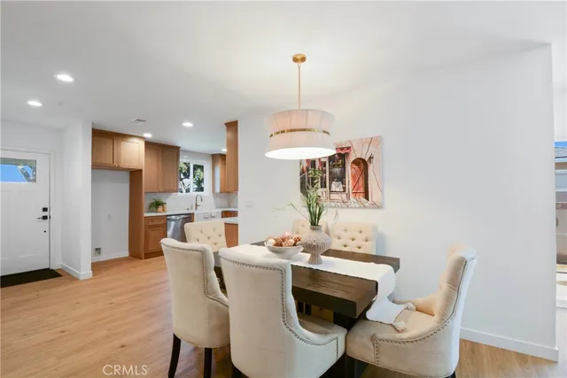 a dining room with furniture a chandelier and wooden floor