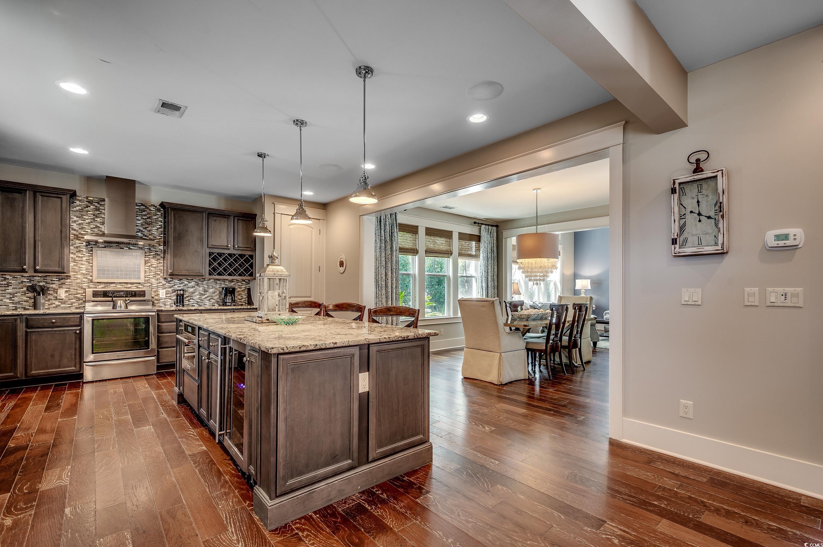 4964 Salt Creek Court North Myrtle Beach, SC 29582 - Photo 17 of 35 Kitchen featuring wall chimney exhaust hood, dark wood-style flooring, stainless steel range, and visible vents