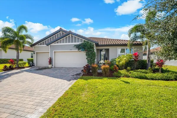 a view of a house with small yard and palm trees
