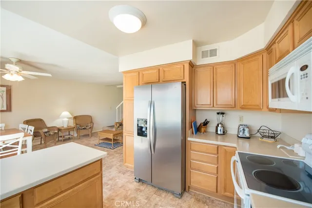 a kitchen with stainless steel appliances granite countertop a sink a stove a refrigerator and a cabinets