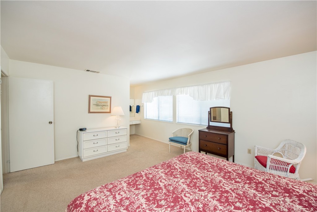 6087 Montecito Circle, Unit 4 Palm Springs, CA 92264 - Photo 20 of 45 a bedroom with a bed dresser and a chair