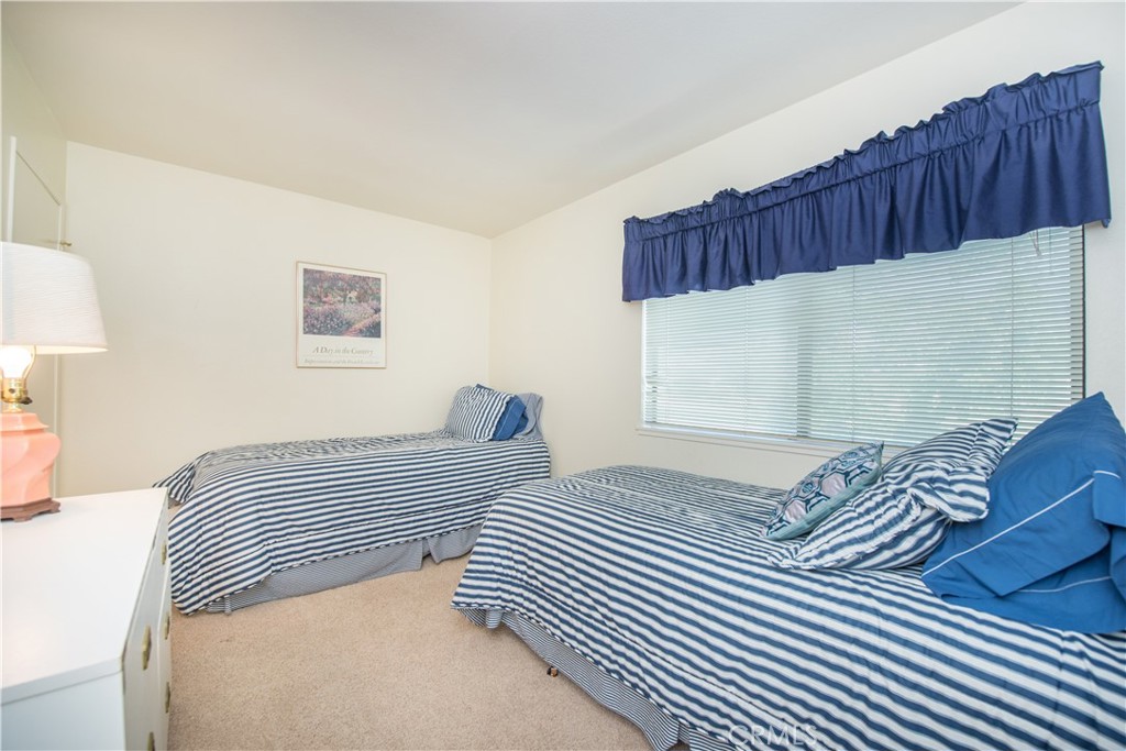 6087 Montecito Circle, Unit 4 Palm Springs, CA 92264 - Photo 26 of 45 a bedroom with a bed and a painting on the wall