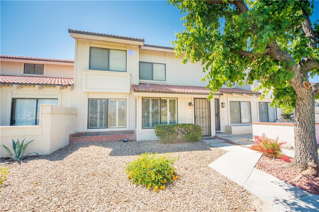 6087 Montecito Circle, Unit 4 Palm Springs, CA 92264 - Photo 35 of 45 a front view of a house with a yard and potted plants