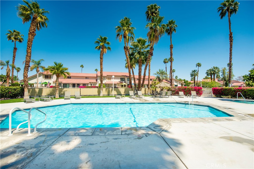 6087 Montecito Circle, Unit 4 Palm Springs, CA 92264 - Photo 43 of 45 a view of a swimming pool with a table and chairs