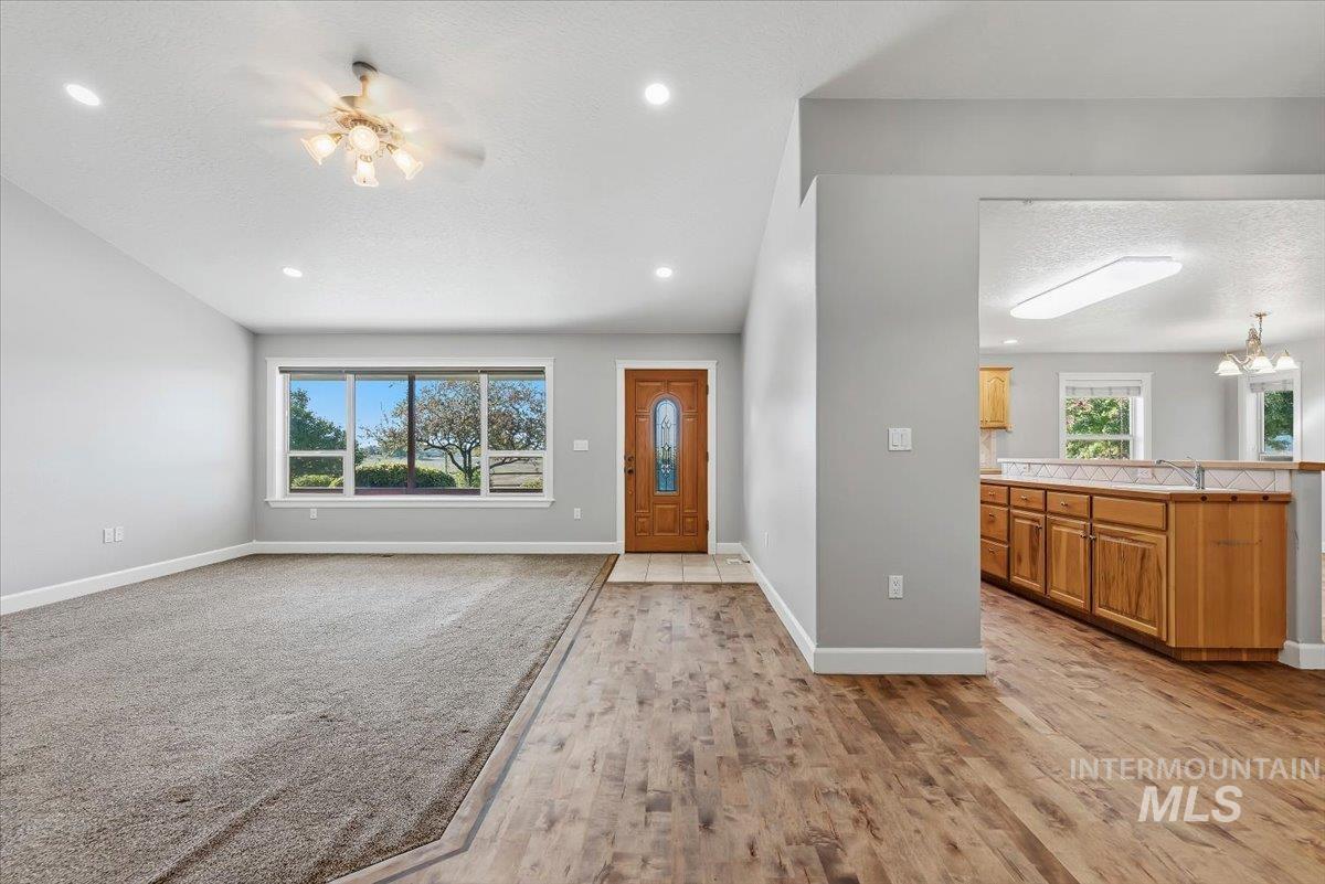 24240 Tiger Lane Caldwell, ID 83607 - Photo 5 of 50 Wood-finish flooring, recessed lighting, ceiling fan, large picture window, and wood cabinetry