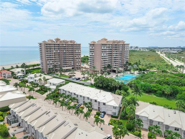 an aerial view of residential houses with outdoor space and ocean