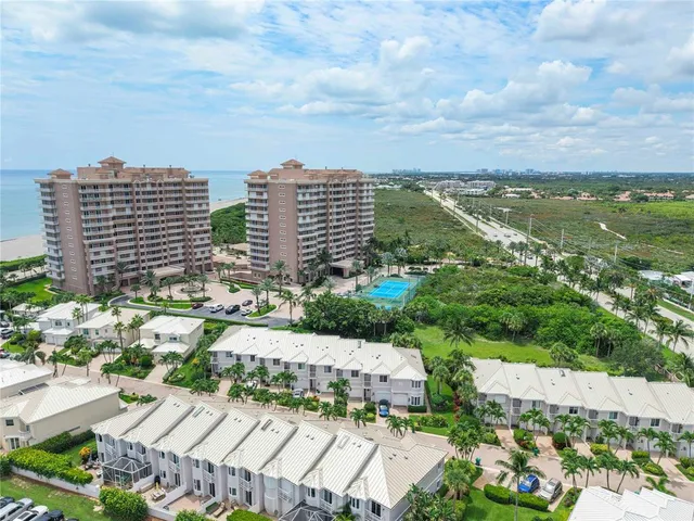 an aerial view of a city with lots of residential buildings ocean and mountain view in back