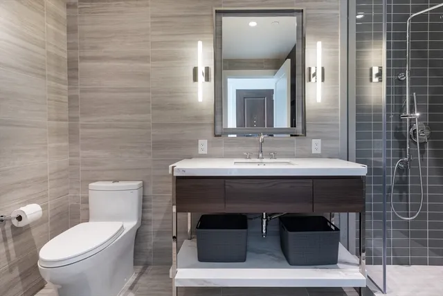 a bathroom with a sink toilet and mirror