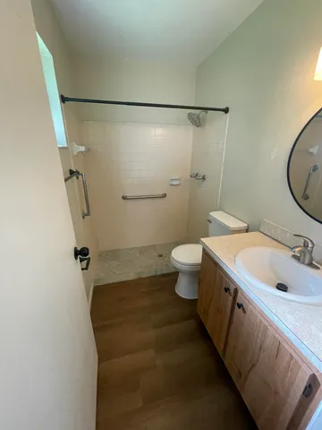 a bathroom with a granite countertop sink toilet and shower