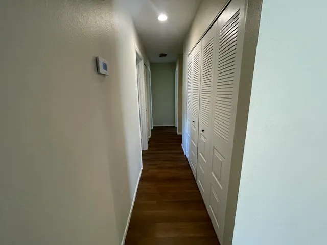 a view of a hallway with wooden floor and staircase