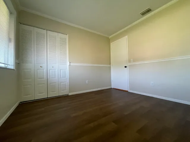 an empty room with wooden floor and door