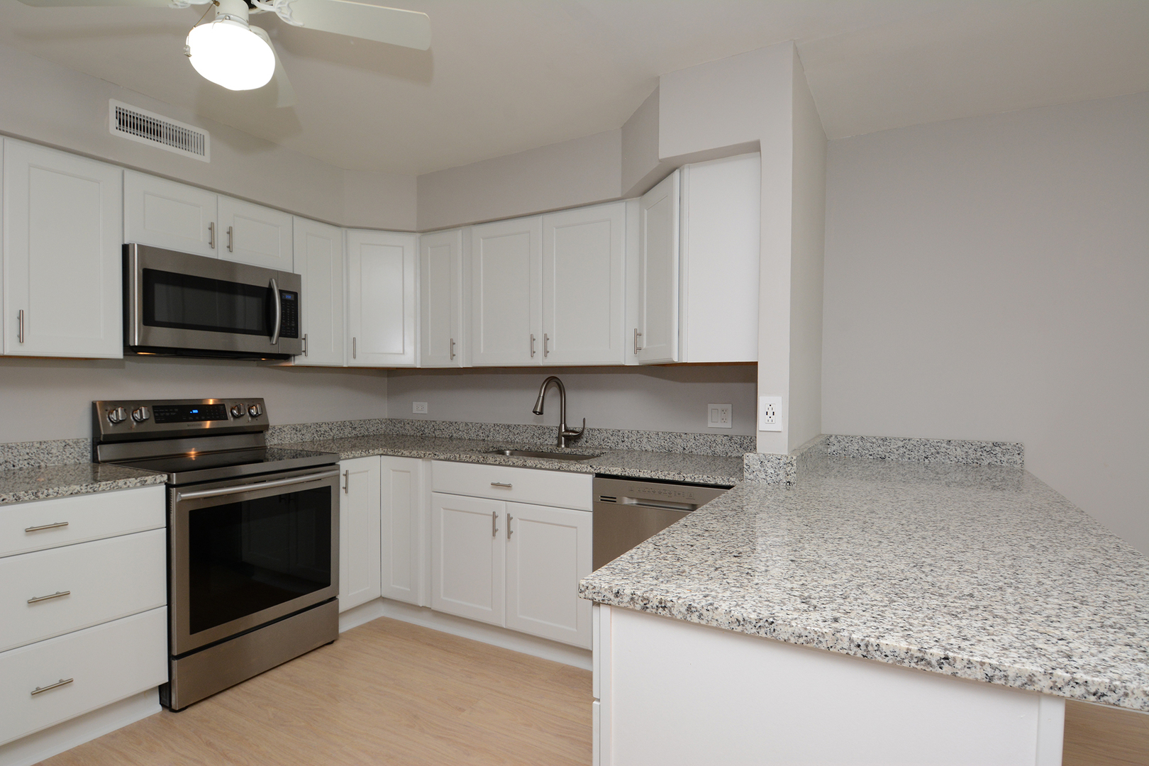 6007 North Sheridan Road, Unit 23D Chicago, IL 60660 - Photo 8 of 22 a kitchen with stainless steel appliances granite countertop a sink stove and microwave