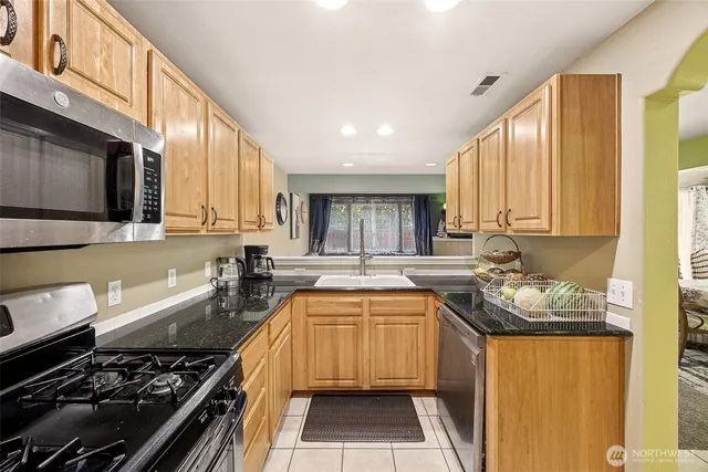 a kitchen with a sink stove top oven and cabinets