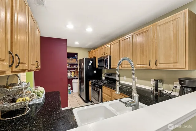 a kitchen with stainless steel appliances a sink a stove and a refrigerator