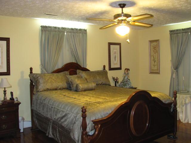 105 Adams Loop Tennessee Ridge, TN 37178 - Photo 5 of 20 a bedroom with a bed and a chandelier