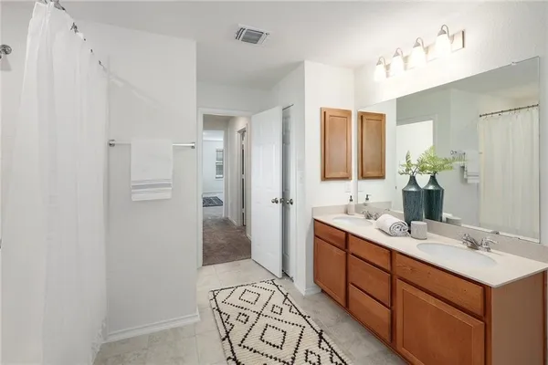 a spacious bathroom with a double vanity sink mirror and shower