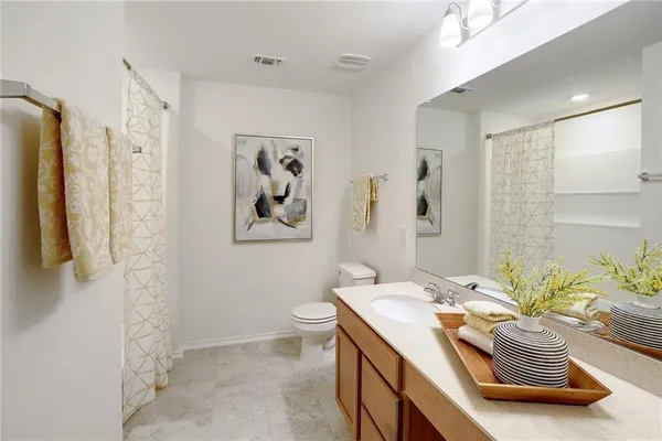 a bathroom with a granite countertop sink a toilet and a shower