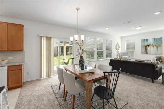 a dining room with furniture a chandelier and wooden floor