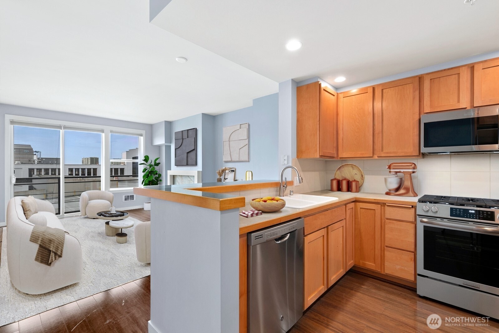 2607 Western Avenue, Unit 452 Seattle, WA 98121 - Photo 6 of 25 a kitchen with stainless steel appliances granite countertop a stove top oven a sink dishwasher a dining table and chairs with wooden floor