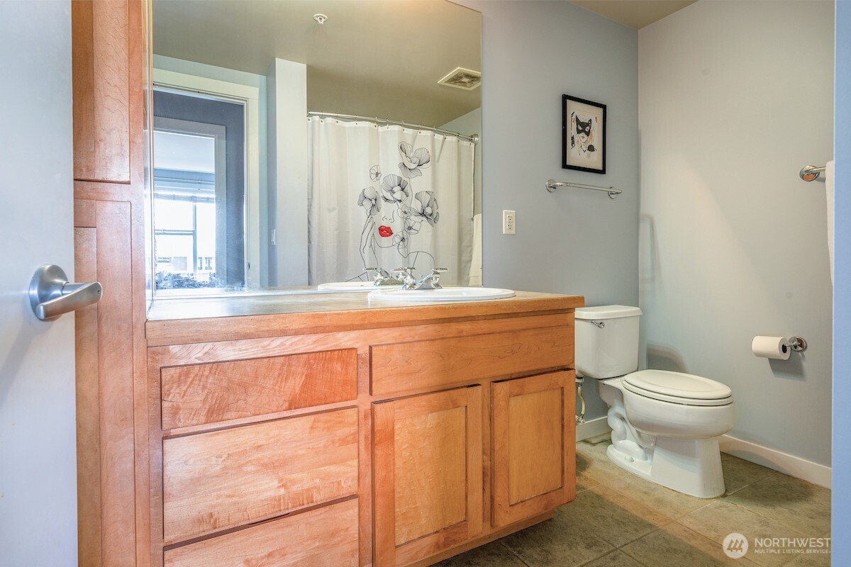 2607 Western Avenue, Unit 452 Seattle, WA 98121 - Photo 10 of 26 a bathroom with a toilet sink and mirror