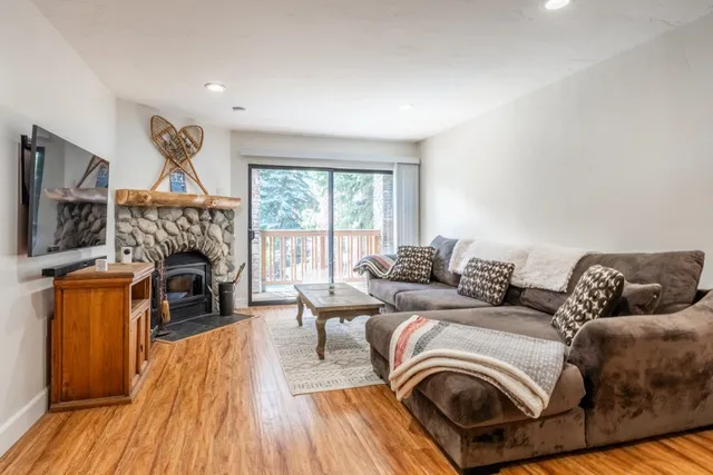 a living room with furniture a fireplace and a wooden floor