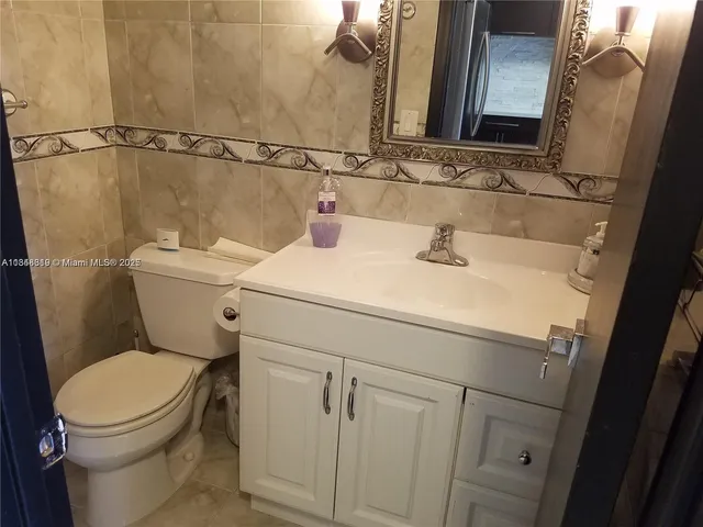 a bathroom with a sink mirror vanity and toilet