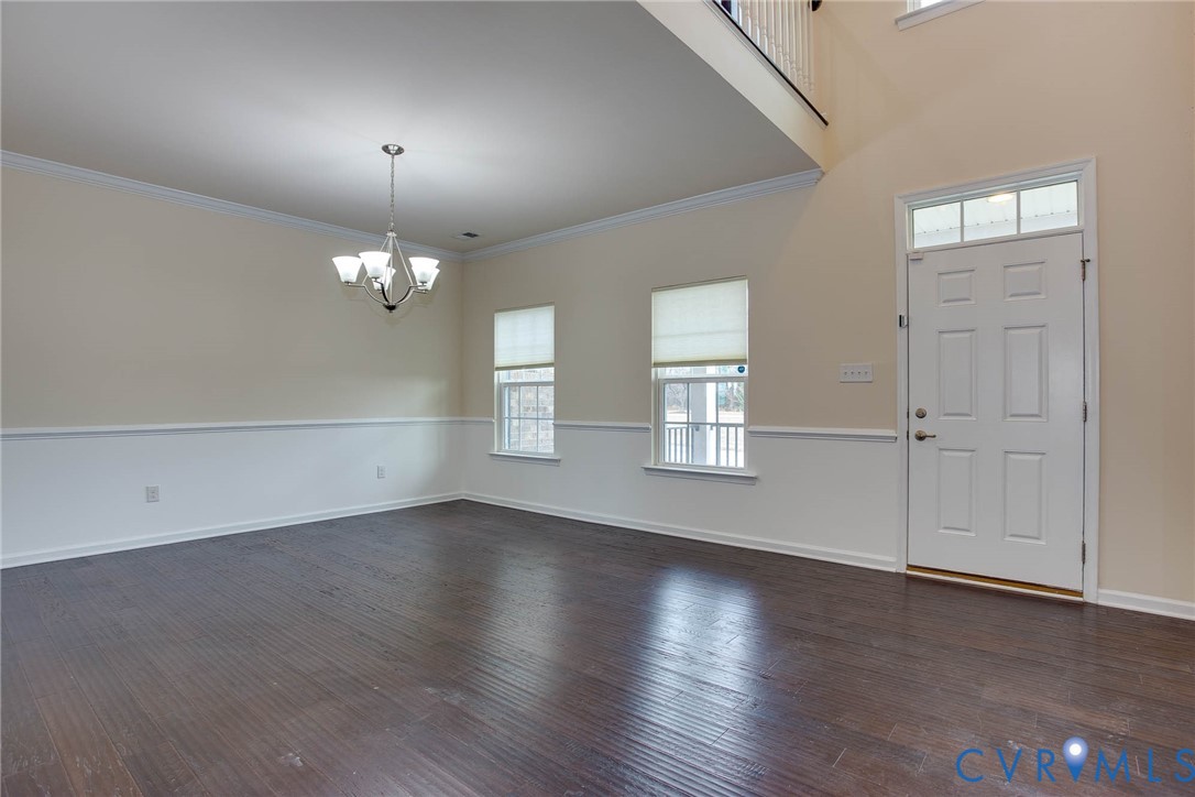12219 Almer Lane Chester, VA 23836 - Photo 8 of 46 an empty room with wooden floor chandelier and windows