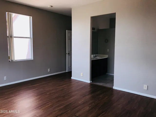 an empty room with wooden floor and closet