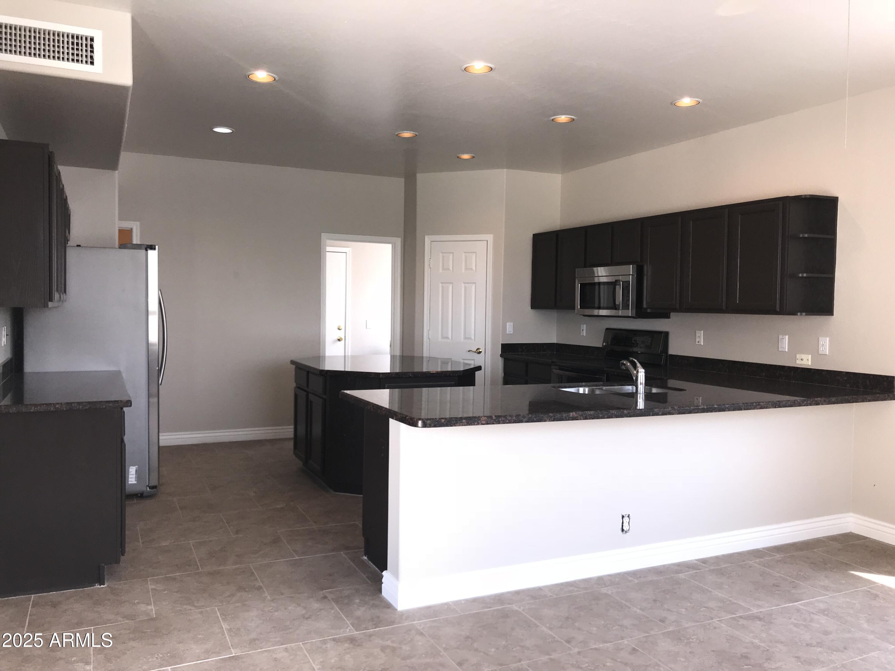 3670 South Heath Way Chandler, AZ 85248 - Photo 8 of 29 a kitchen with stainless steel appliances a sink and a refrigerator