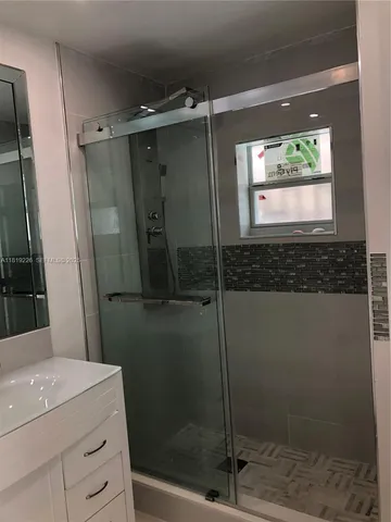 a bathroom with a shower a mirror and a sink