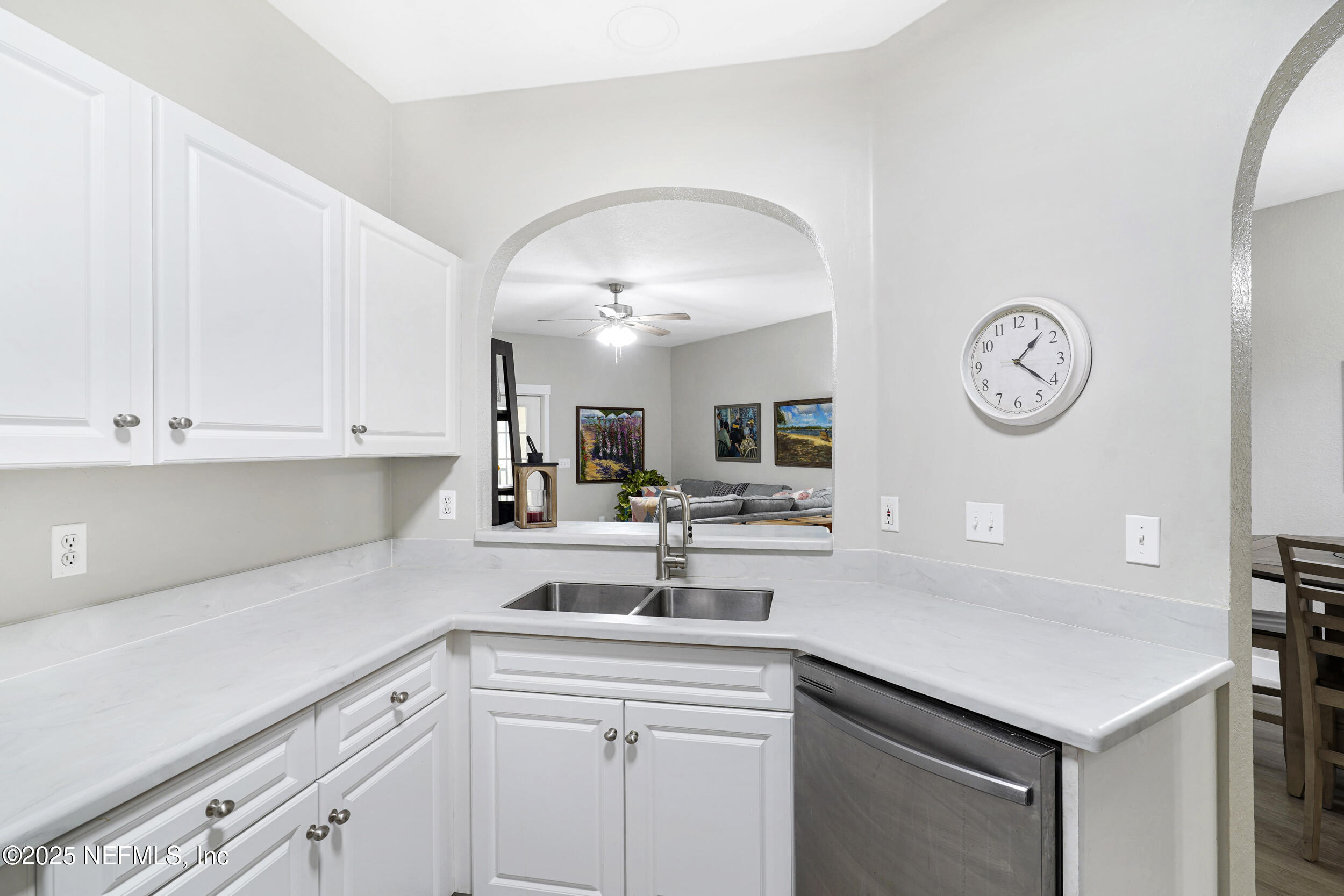 1125 Vista Cove Road St. Augustine, FL 32084 - Photo 12 of 62 a kitchen with sink cabinets and a clock on the wall