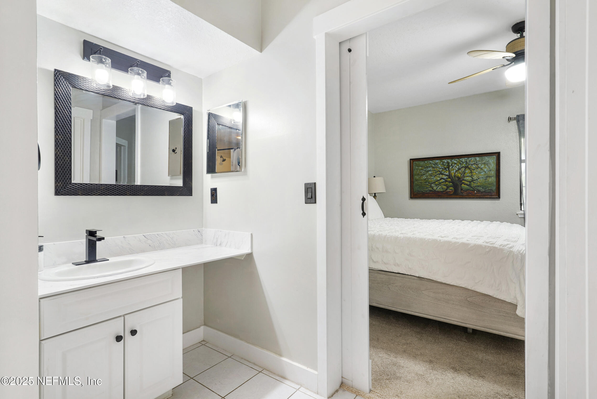 1125 Vista Cove Road St. Augustine, FL 32084 - Photo 18 of 62 a en suite bathroom with a double vanity sink a mirror and a bathtub