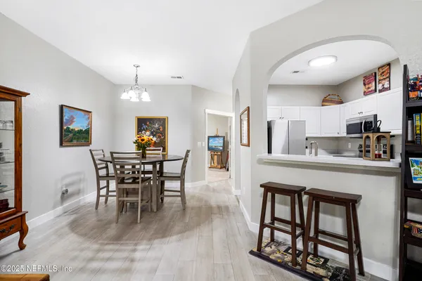 a view of a hallway with wooden floor and a living room