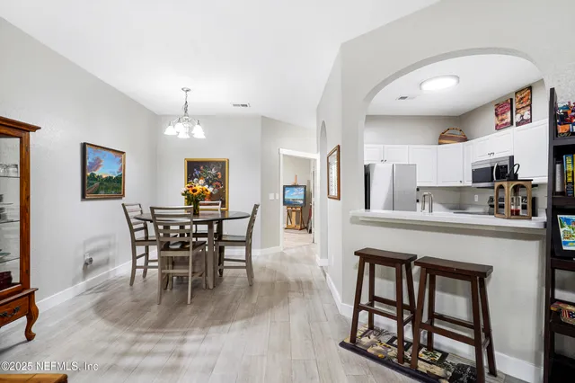 a view of a hallway with wooden floor and a living room