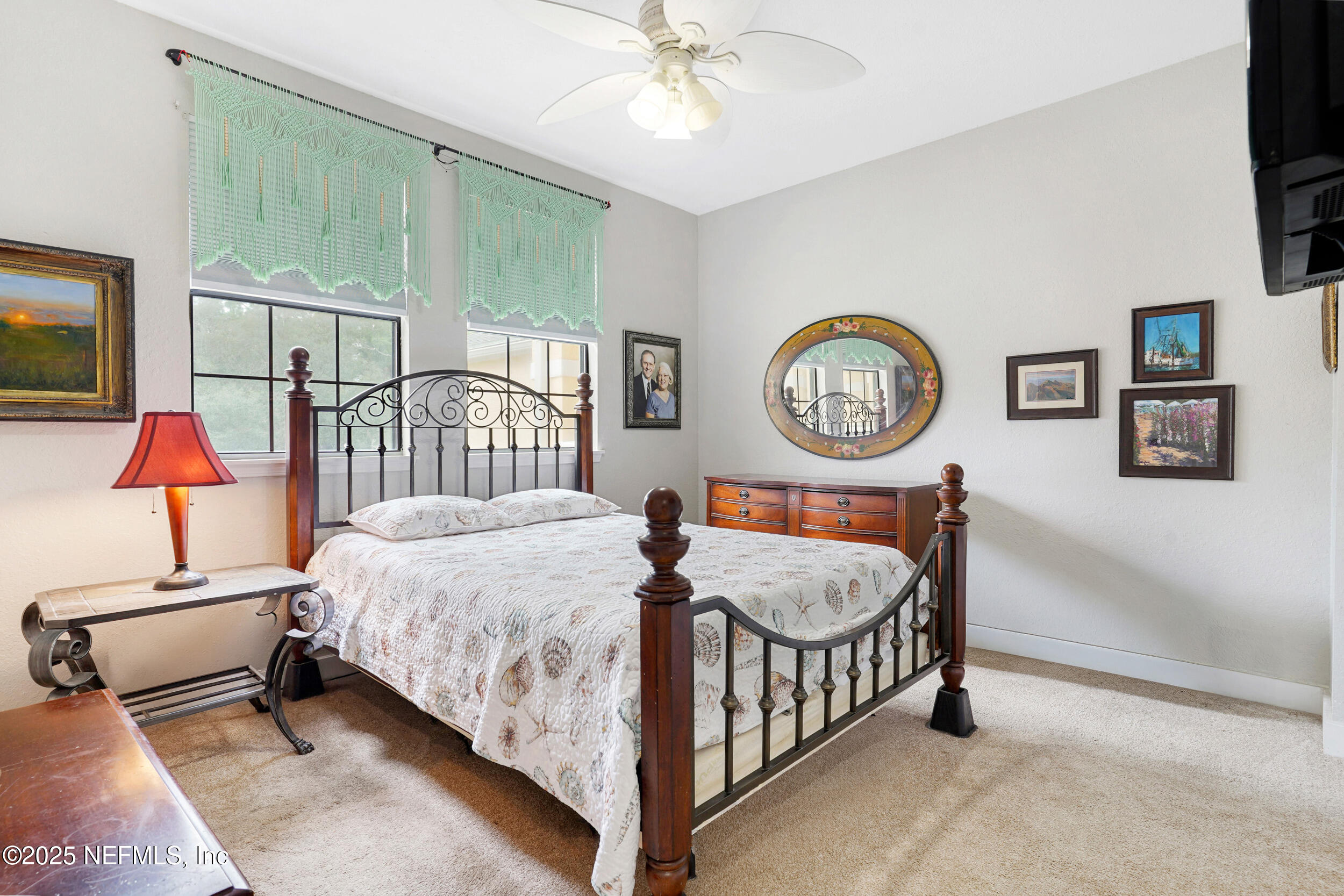 1125 Vista Cove Road St. Augustine, FL 32084 - Photo 31 of 62 a bedroom with a bed a clock on the wall and a table