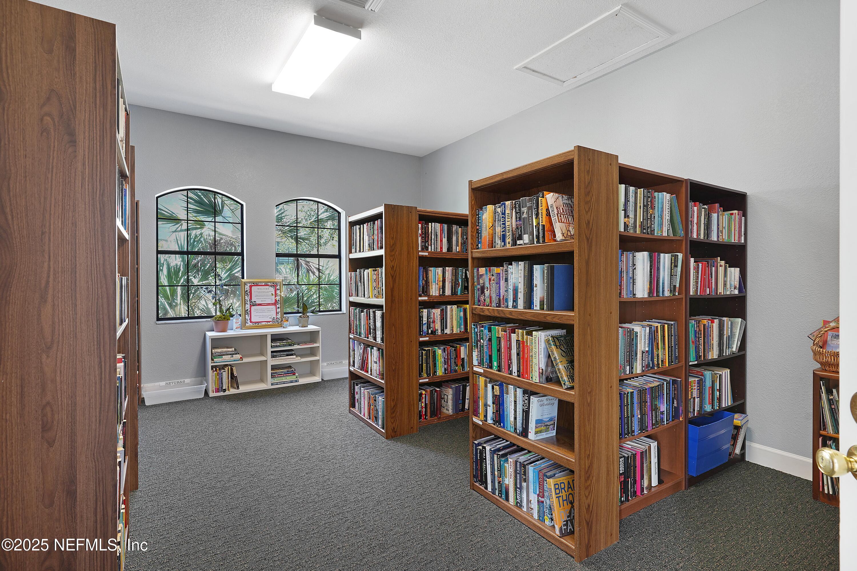 1125 Vista Cove Road St. Augustine, FL 32084 - Photo 58 of 62 a living room with fireplace furniture and a book shelf