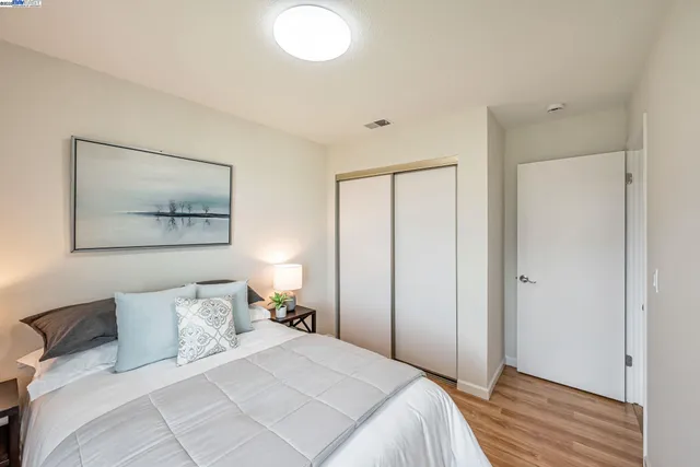 a bedroom with a bed and wooden floor