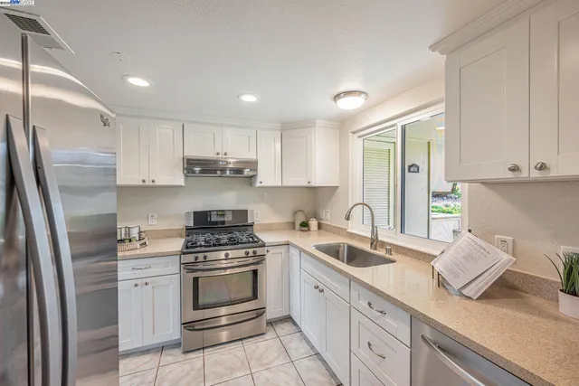 a kitchen with stainless steel appliances a sink stove and cabinets