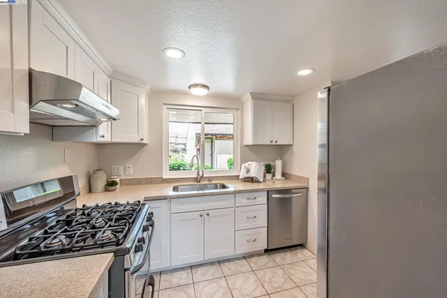 a living room with furniture potted plant and open kitchen view