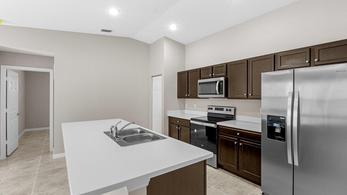 1213 Ragen Road Southeast Palm Bay, FL 32909 - Photo 12 of 26 a kitchen with a refrigerator stove and microwave