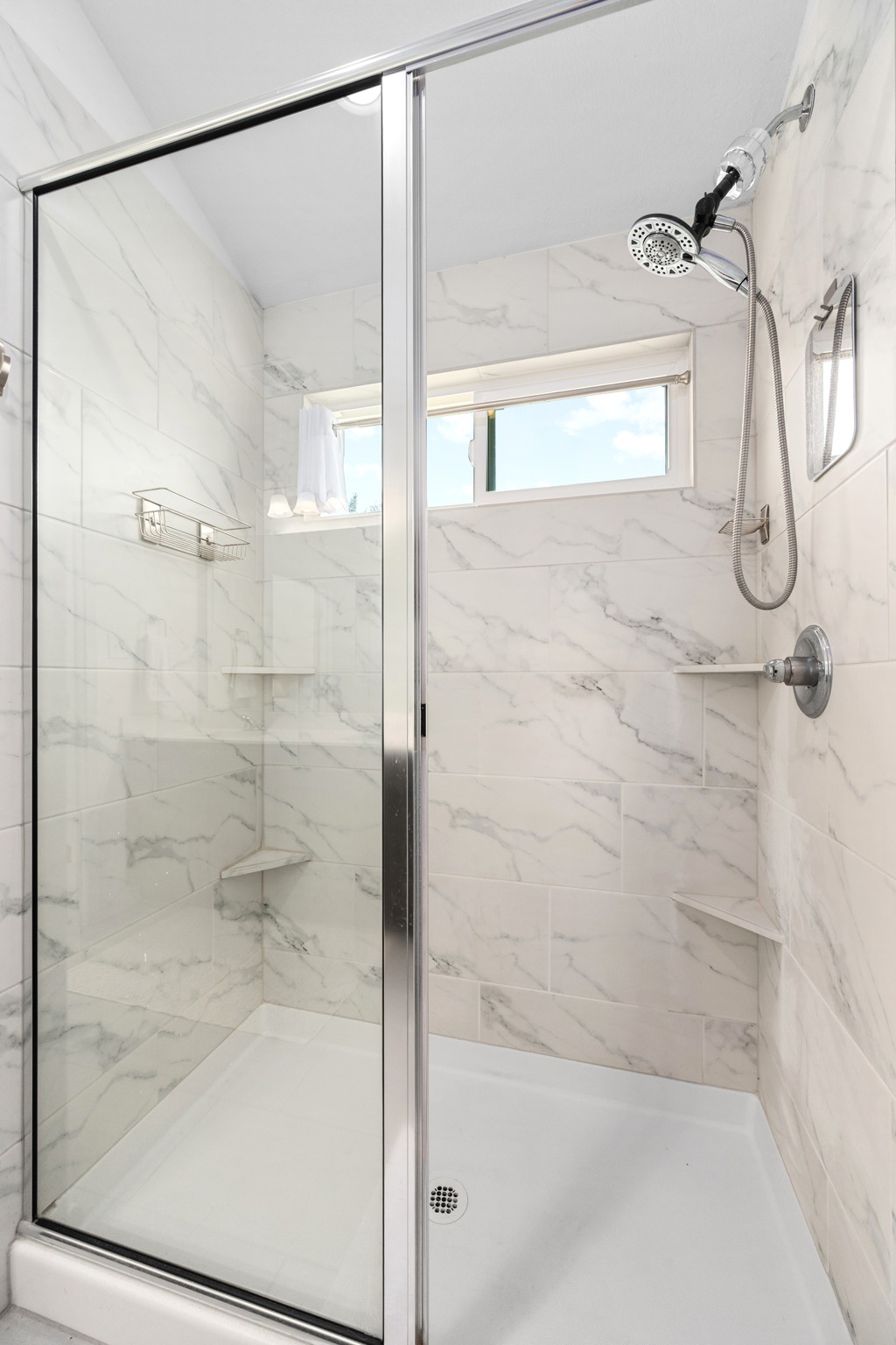 21006 Santa Rosa Avenue Lago Vista, TX 78645 - Photo 12 of 26 A well-appointed shower stall features a contemporary glass enclosure and sleek marble-patterned tilework.