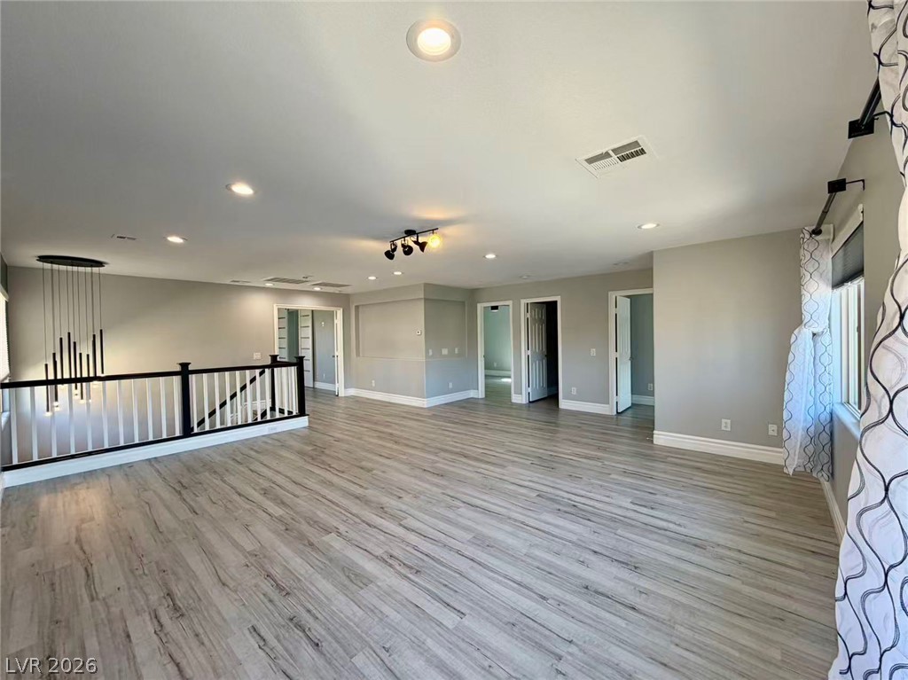 135 Tall Ruff Drive Las Vegas, NV 89148 - Photo 13 of 29 A spacious, naturally illuminated room featuring plank flooring and recessed lighting.
