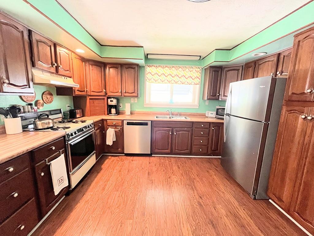 1192 Washington Street Indiana, PA 15701 - Photo 7 of 19 a kitchen with wooden floors stainless steel appliances a window and a counter