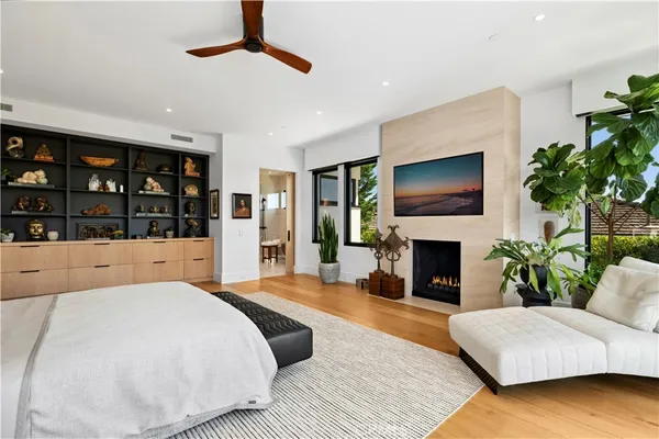 a spacious bedroom with a large bed a flat tv screen and a fireplace