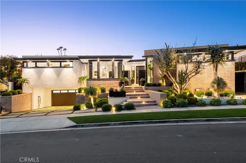 a front view of a house with a garden and yard
