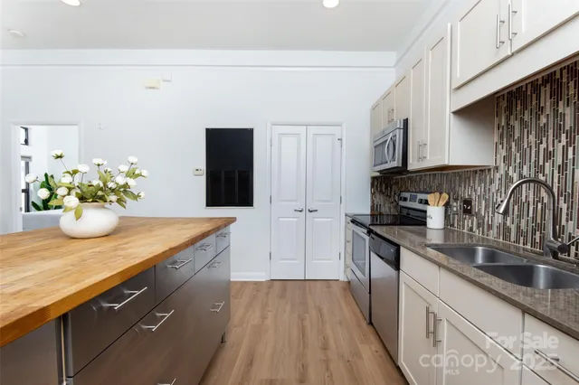 a kitchen with stainless steel appliances granite countertop a sink a stove and cabinets