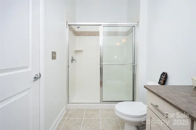 a bathroom with a granite countertop toilet a sink and a shower