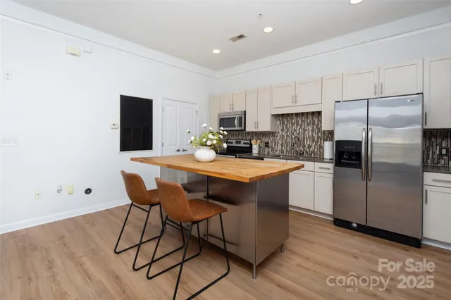 a kitchen with a table chairs refrigerator and microwave